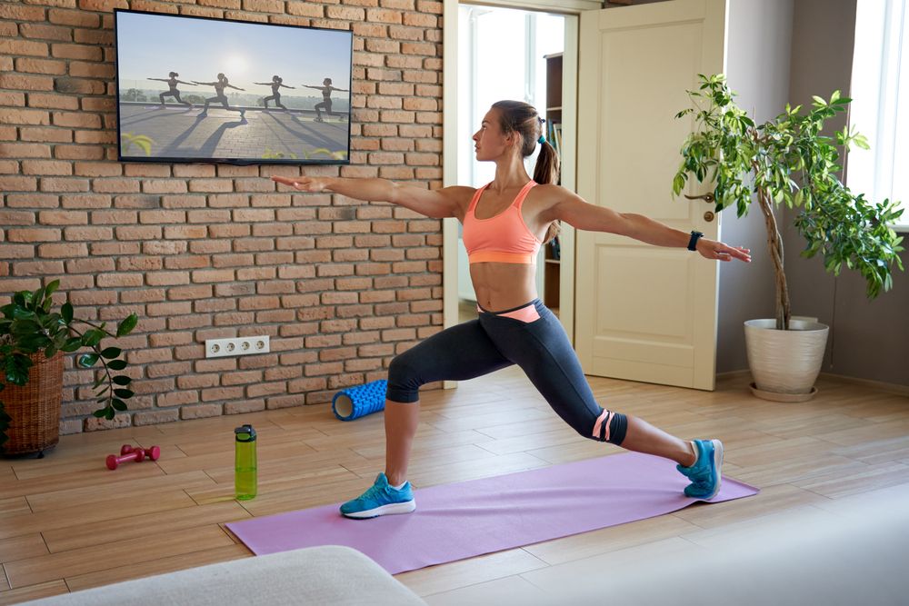 Girl making a throw while watching fitness TV